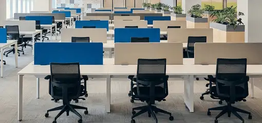 Modern open-plan office space featuring clean workstations, ergonomic chairs, and sanitized carpets provided by professional office cleaning services in Dayton, OH.